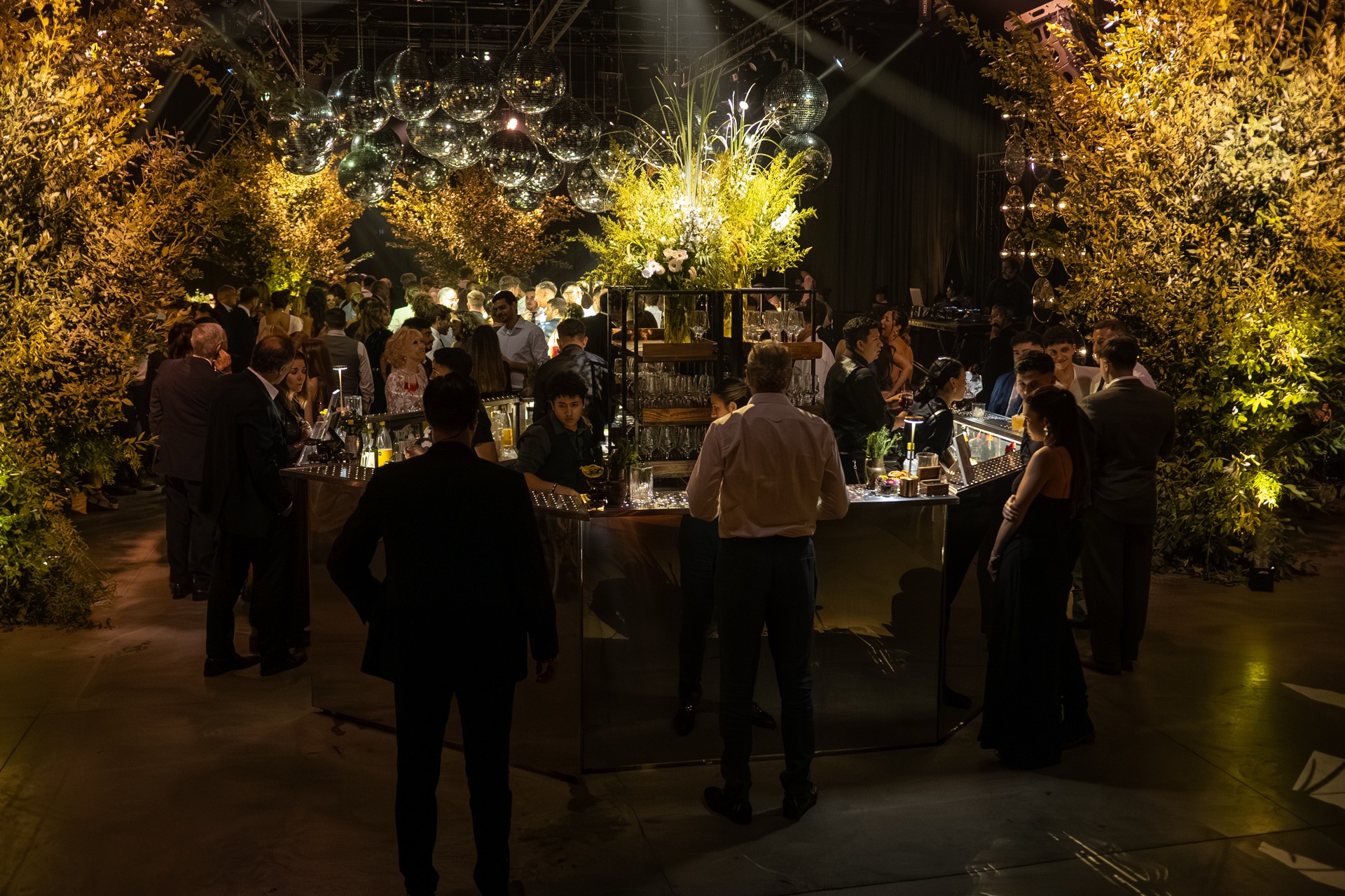 Isla hexagonal Green Bar en evento con plantas y luces
